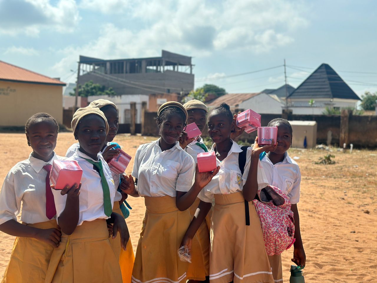 Students holding up CyLanK pad boxes outdoors